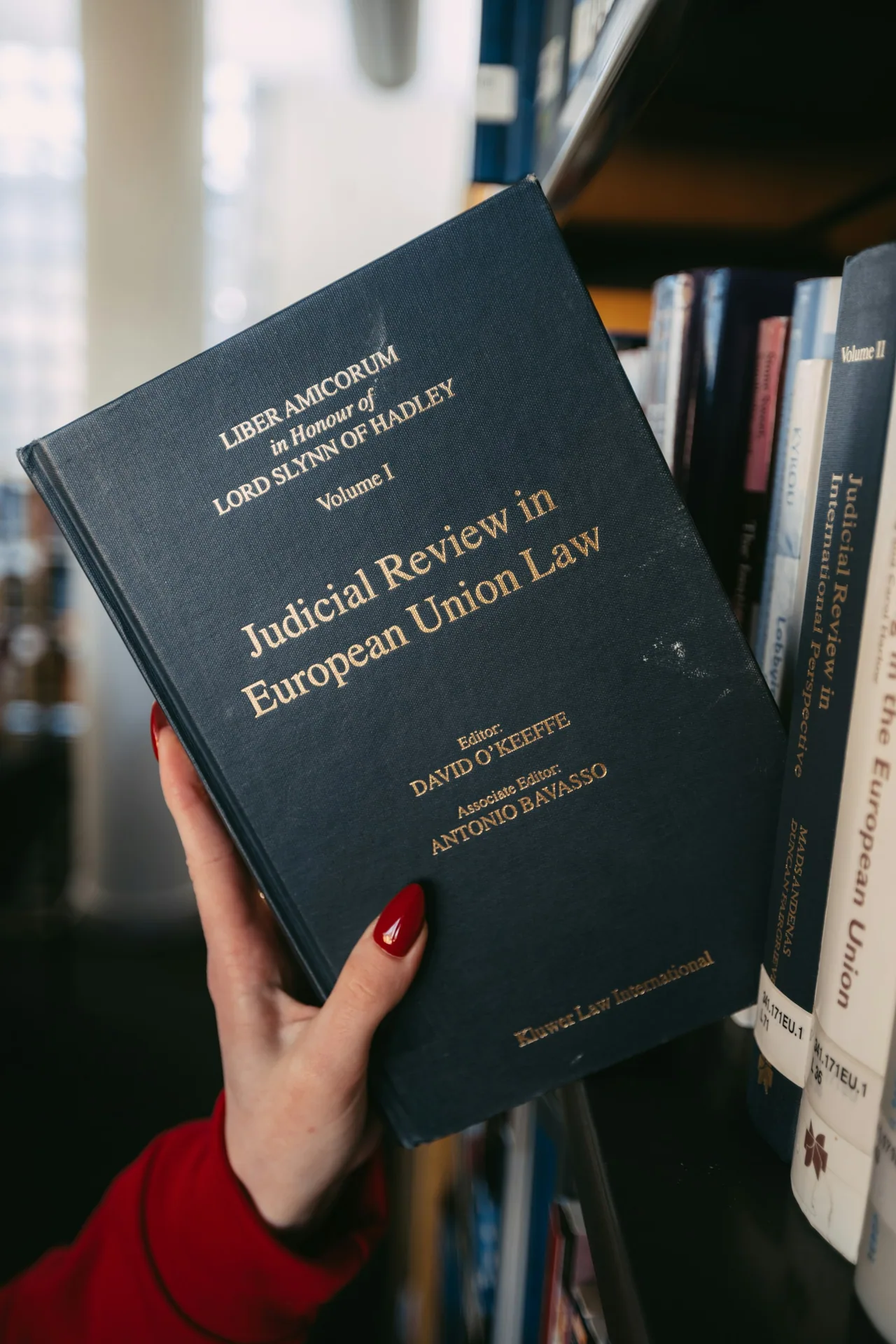 A hand holds a book about European Union law