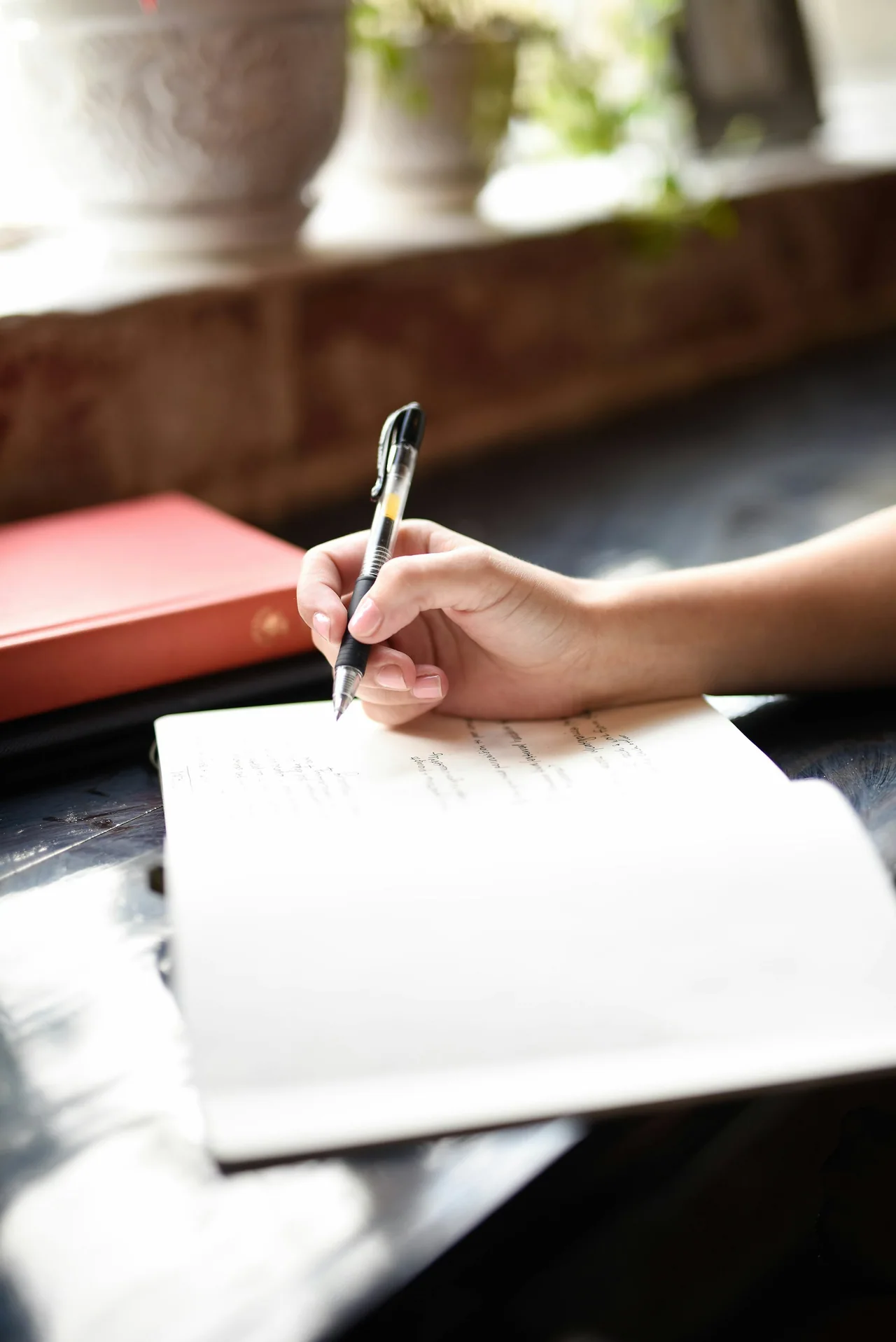 A person writes notes with a pen