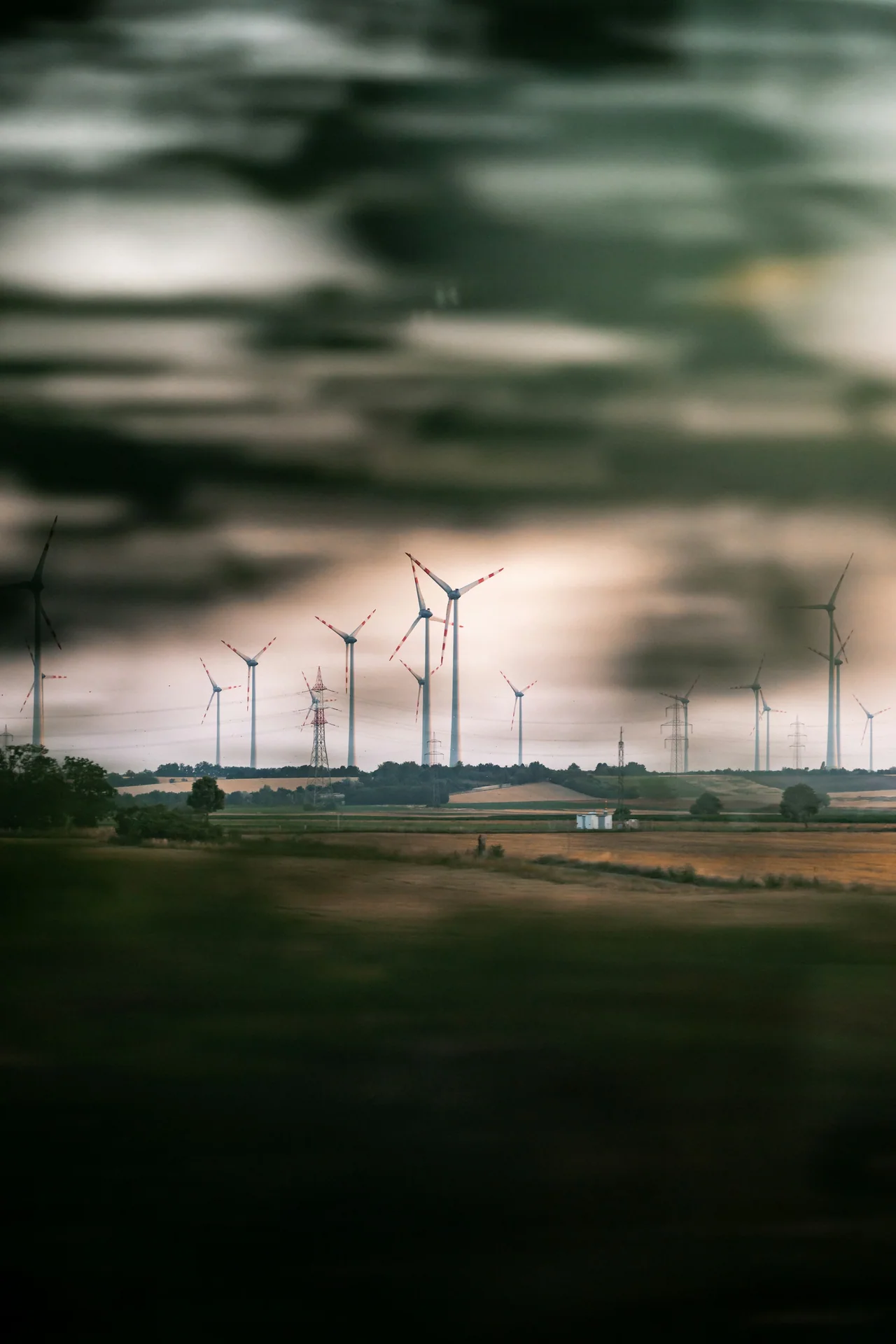 Wind turbines across a field beneath a colourful cloudy sky.