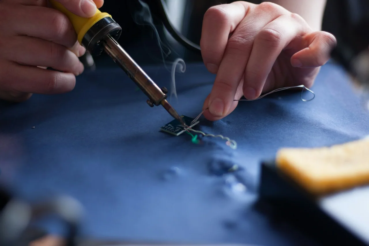 Hands soldering an electronic board